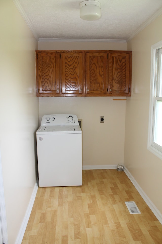 laundry area featuring cabinets, washer / clothes dryer, crown molding, and light hardwood / wood-style flooring