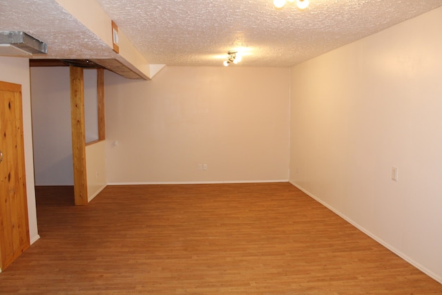 basement with a textured ceiling and hardwood / wood-style flooring