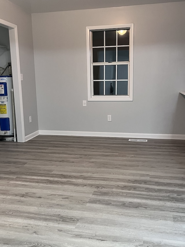 spare room with water heater and hardwood / wood-style floors