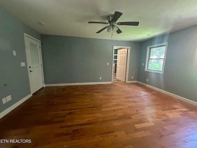 spare room featuring a ceiling fan, baseboards, and wood finished floors