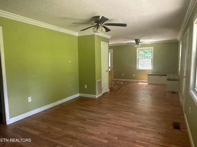 unfurnished room featuring a textured ceiling, wood finished floors, a ceiling fan, and ornamental molding