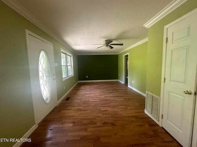 foyer entrance with dark wood-style floors, baseboards, visible vents, and ornamental molding