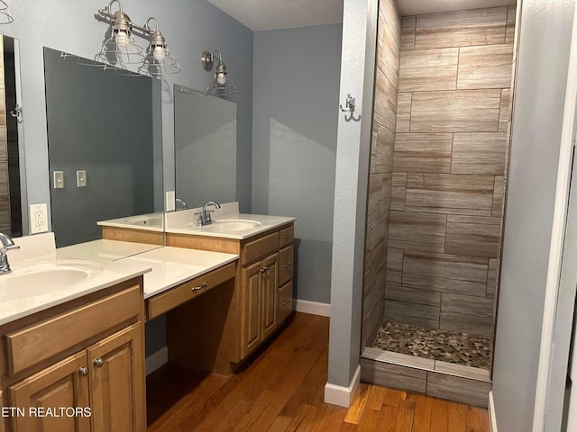 full bathroom with wood finished floors, two vanities, and a sink