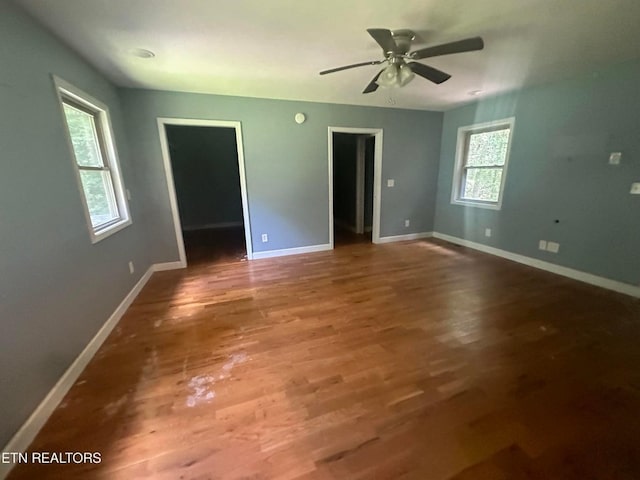 unfurnished room with a ceiling fan, wood finished floors, and baseboards