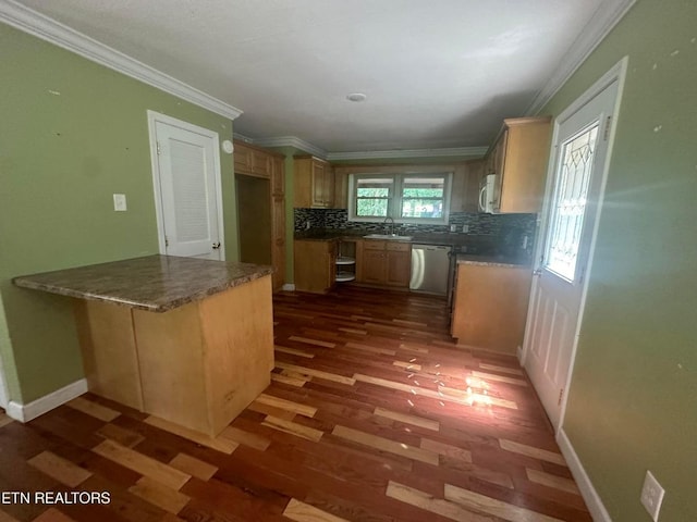 kitchen featuring dark countertops, appliances with stainless steel finishes, backsplash, crown molding, and a sink