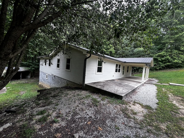 back of property featuring gravel driveway and a carport