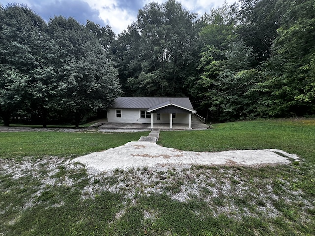 view of front facade with metal roof, a patio, and a front yard