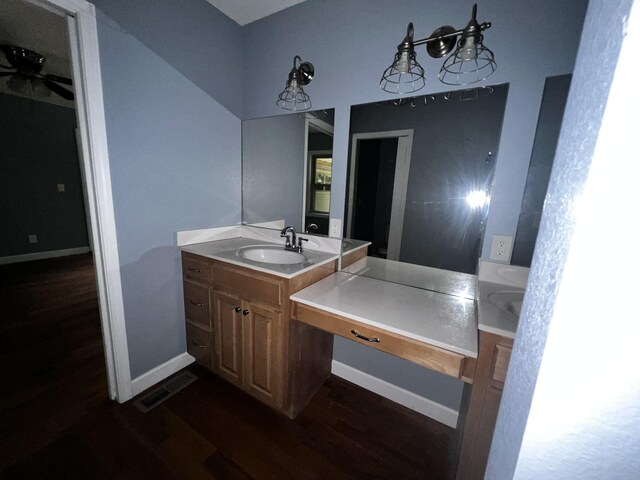 bathroom featuring visible vents, ceiling fan, vanity, wood finished floors, and baseboards