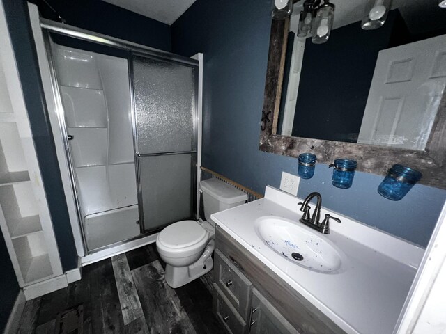 full bath with toilet, a shower stall, vanity, and wood finished floors