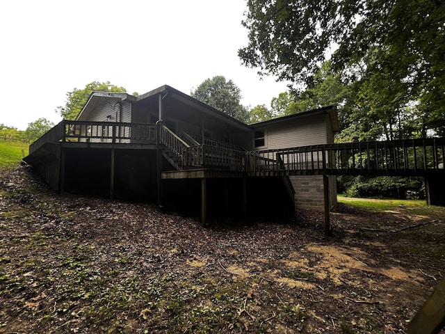 back of house featuring a wooden deck and stairs