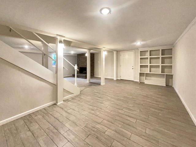 basement featuring hardwood / wood-style flooring and a brick fireplace