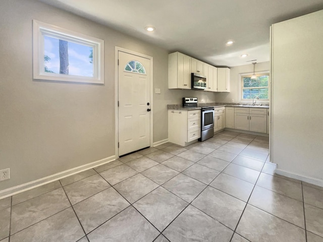 kitchen featuring white cabinetry, appliances with stainless steel finishes, sink, and light tile patterned floors