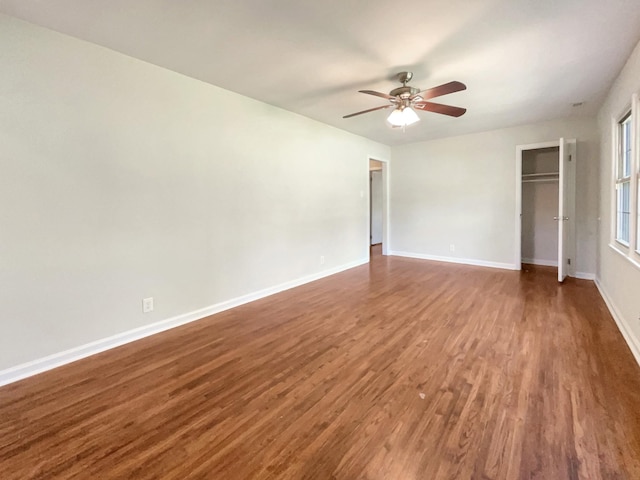 unfurnished room with ceiling fan and dark hardwood / wood-style flooring