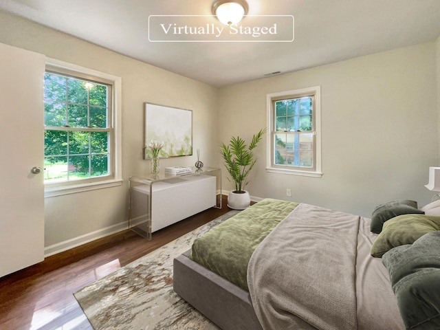 bedroom with dark hardwood / wood-style flooring