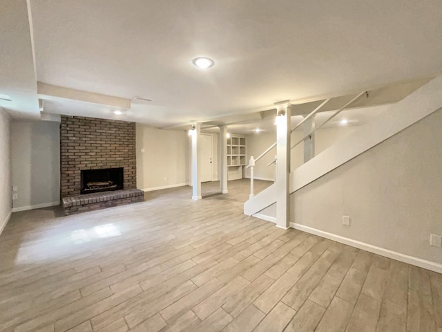 basement with a fireplace and light hardwood / wood-style floors