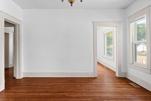 unfurnished room with dark wood-type flooring