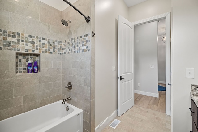 bathroom with vanity, hardwood / wood-style flooring, and tiled shower / bath combo