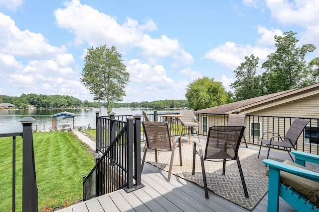 wooden terrace featuring a water view and a lawn