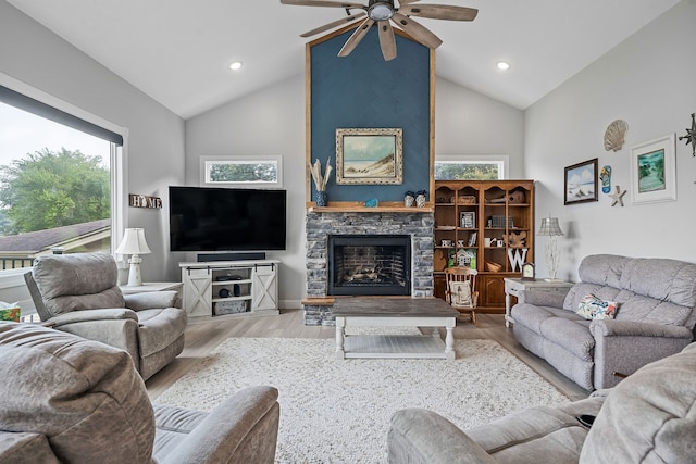 living room with a fireplace, light hardwood / wood-style floors, high vaulted ceiling, and ceiling fan