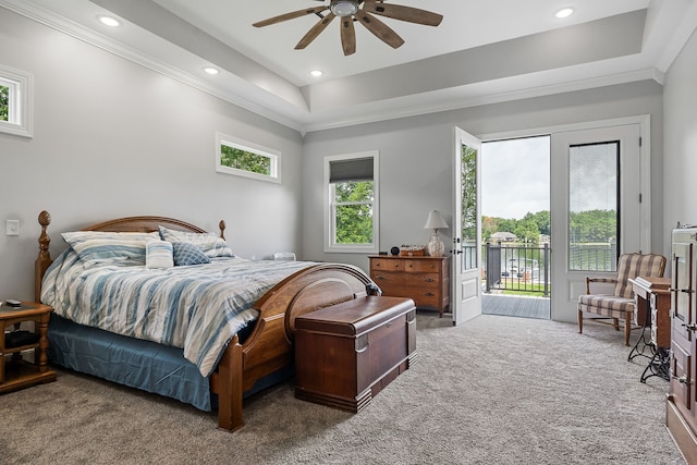 bedroom featuring ceiling fan, a tray ceiling, ornamental molding, carpet floors, and access to exterior