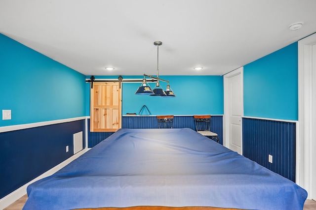 rec room featuring wood-type flooring and a barn door