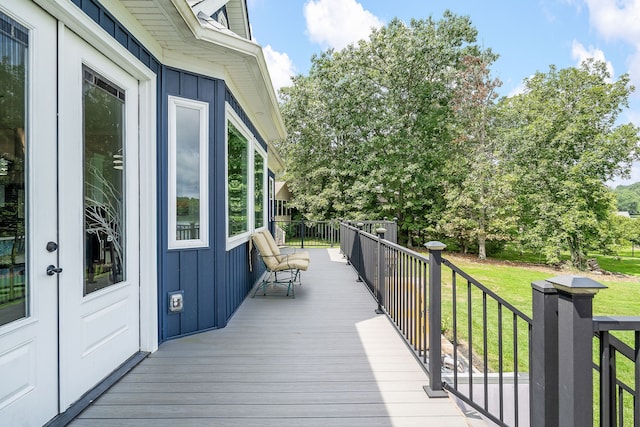 wooden terrace featuring a lawn