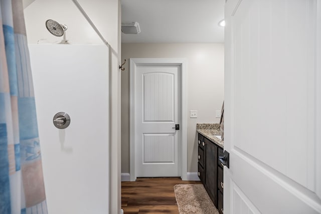 bathroom with vanity, wood-type flooring, and walk in shower