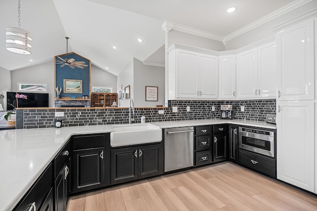 kitchen with stainless steel dishwasher, oven, light hardwood / wood-style flooring, and white cabinetry