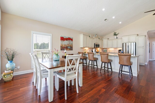 dining space featuring lofted ceiling, wood-type flooring, and ceiling fan