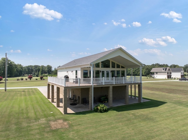 rear view of house with a patio, a lawn, and a deck