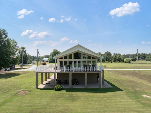 back of house featuring a lawn, a wooden deck, stairs, and a patio