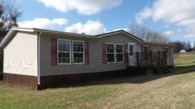 view of home's exterior with a lawn and a deck