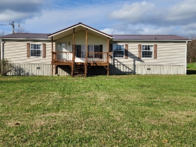 rear view of house featuring a wooden deck and a yard