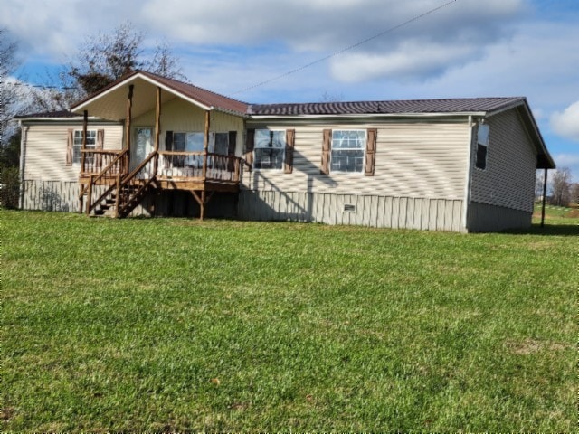 back of property with a lawn and a deck