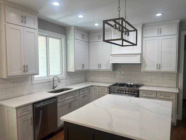 kitchen featuring sink, tasteful backsplash, decorative light fixtures, appliances with stainless steel finishes, and light stone countertops