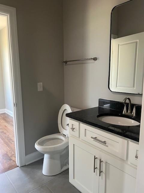 bathroom featuring vanity, tile patterned flooring, and toilet