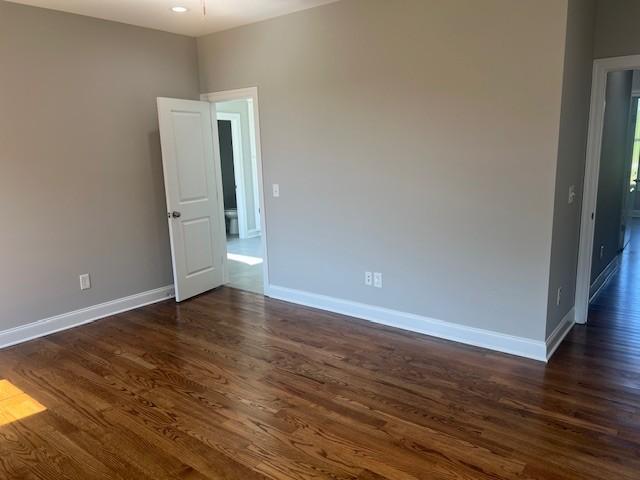 empty room with dark wood-type flooring