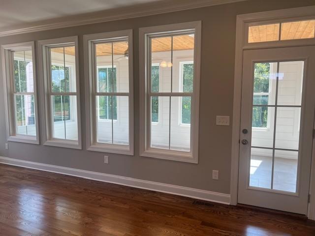 entryway featuring crown molding and dark hardwood / wood-style floors