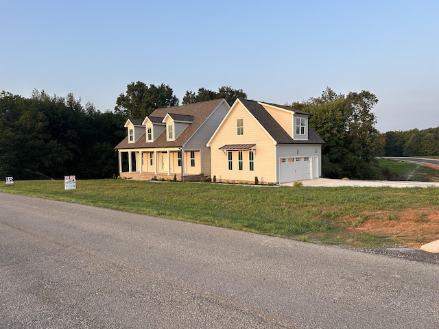 view of front of home with a porch, a garage, and a front lawn