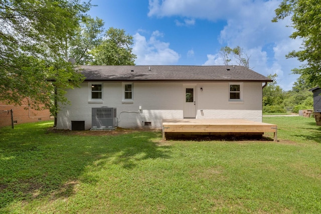 back of property featuring cooling unit, brick siding, a lawn, and a deck