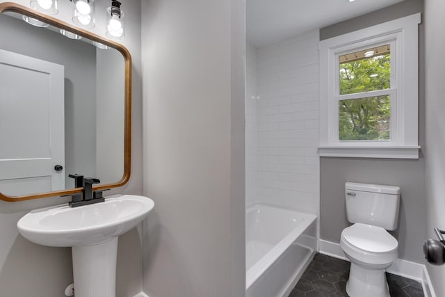 bathroom featuring tile patterned flooring, toilet, and baseboards