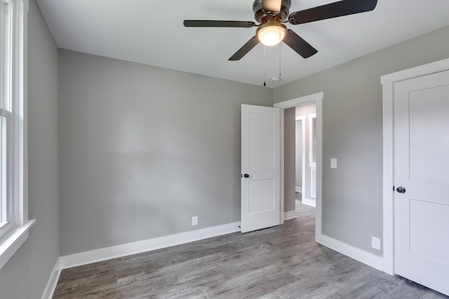 unfurnished bedroom featuring ceiling fan, baseboards, and wood finished floors