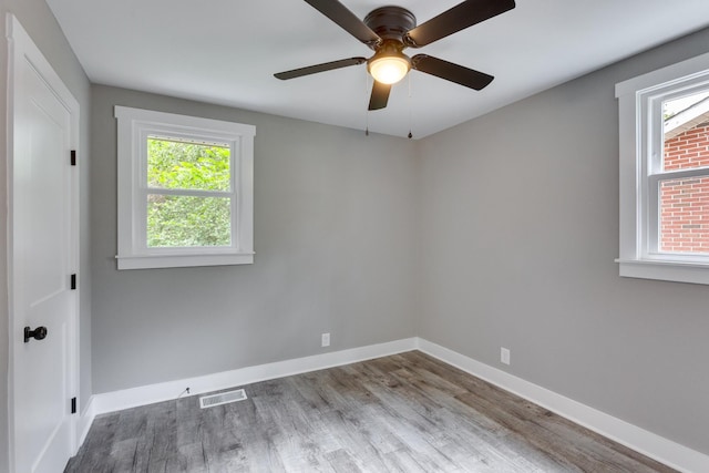 unfurnished room with visible vents, ceiling fan, baseboards, and wood finished floors