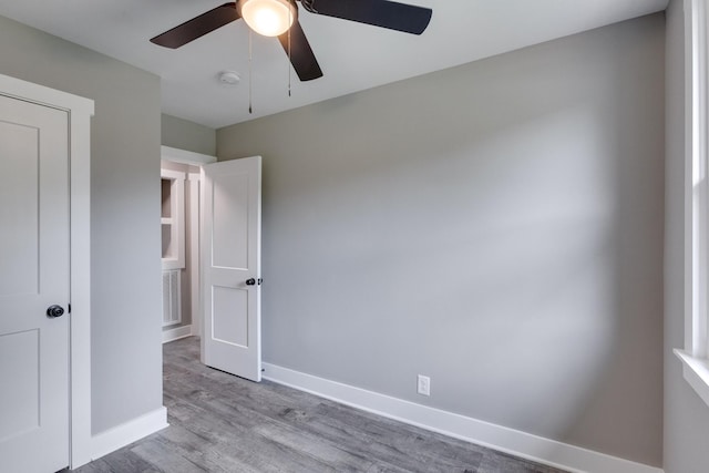 unfurnished bedroom with wood finished floors, a ceiling fan, and baseboards