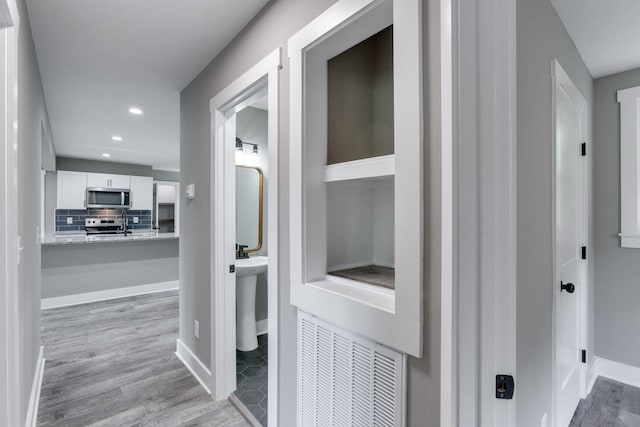 corridor with visible vents, baseboards, wood finished floors, and recessed lighting