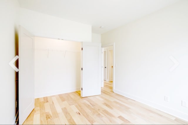 unfurnished bedroom featuring light hardwood / wood-style flooring and a closet