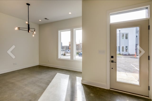 entryway with carpet flooring and a chandelier