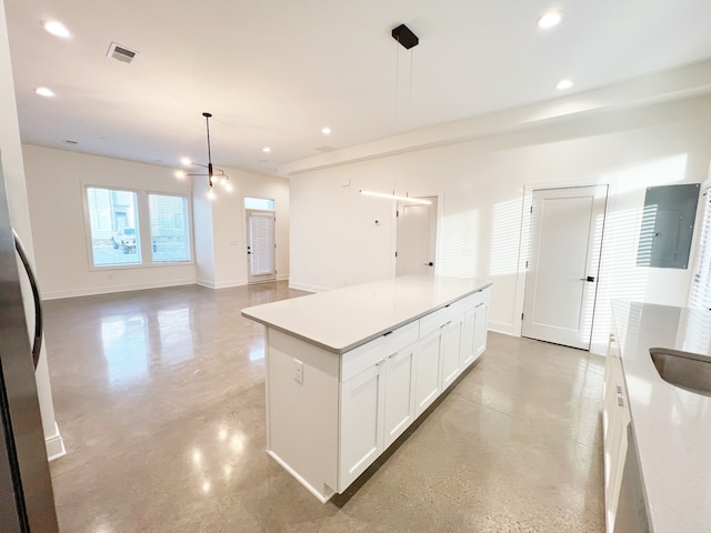 kitchen with decorative light fixtures, white cabinets, and a kitchen island