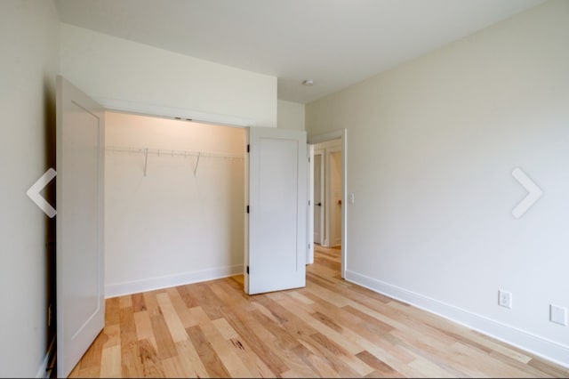 unfurnished bedroom with a closet and light wood-type flooring