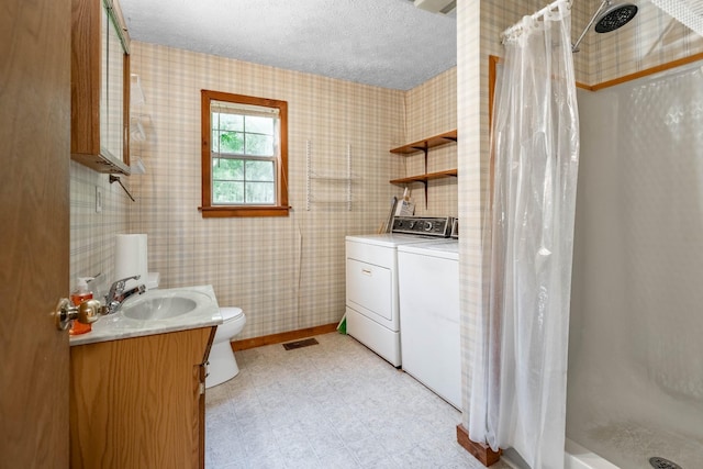 bathroom featuring washer and clothes dryer, visible vents, toilet, a shower with shower curtain, and a textured ceiling